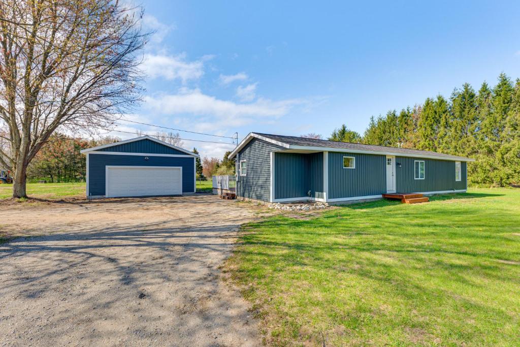 a house with a garage in a yard at Less Than 3 Mi to Double JJ Resort Home with Large Yard! in Rothbury