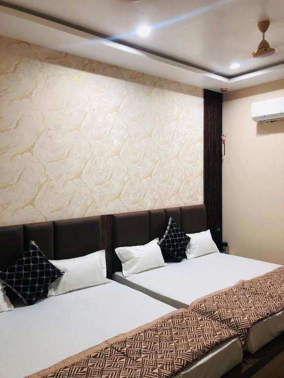 a bedroom with a large bed with black and white pillows at Hotel Ram Ghar - Near Mathura Junction Railway Station in Mathura