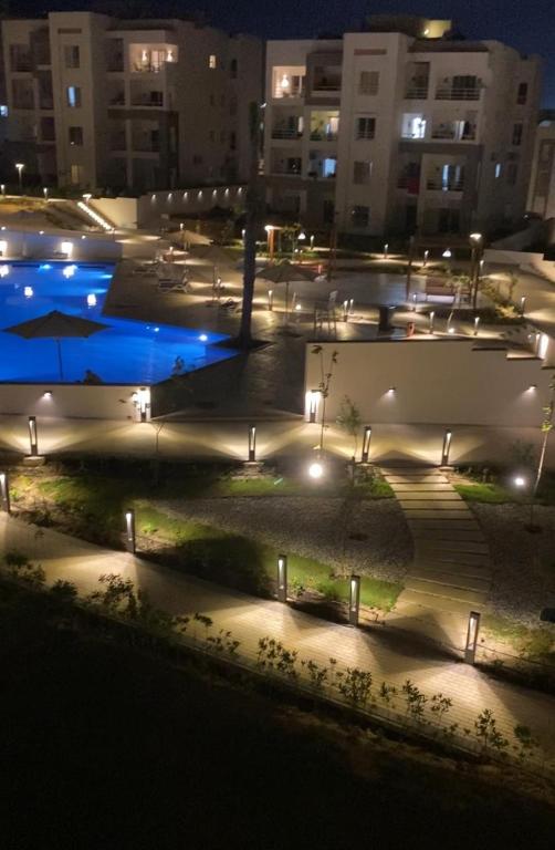 a courtyard with a pool at night with lights at Amwaji in El Alamein