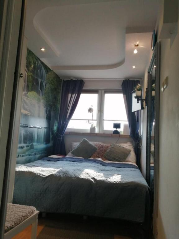 a bedroom with a bed and a window in it at Apartamenty na doby in Siedlce