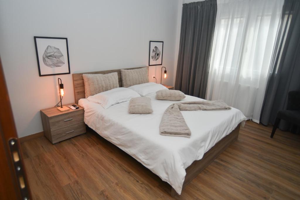 a bedroom with a large bed with white sheets and pillows at Black and white suites 2 in Thessaloniki