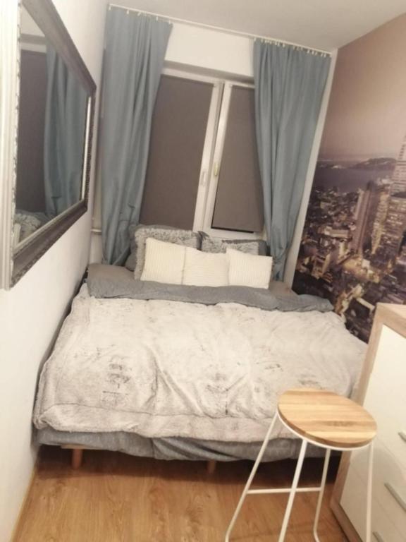 a small bedroom with a bed and a window at Apartamenty na doby in Siedlce