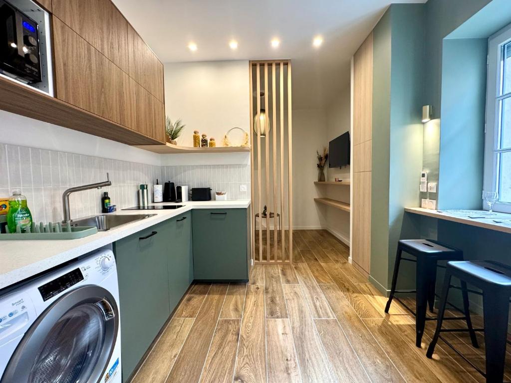 une cuisine avec une machine à laver et un lave-linge dans l'établissement L'Écrin de Duguesclin Comfort & Charm in Lyon 3rd arrondissement, à Lyon