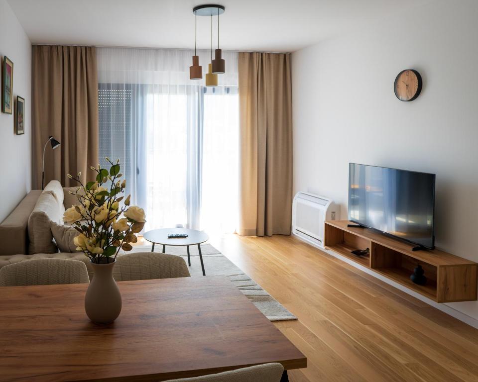 a living room with a vase of flowers on a table at Apartman Sara Trebinje in Trebinje