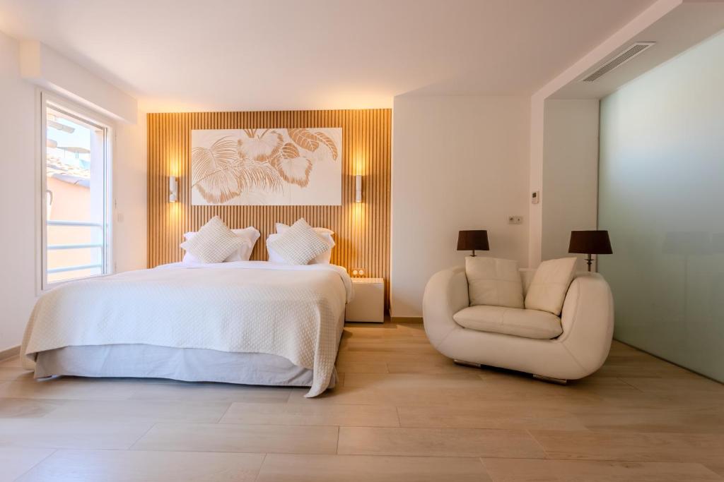 a bedroom with a white bed and a chair at Hôtel Traverse Des Artistes in Cannes
