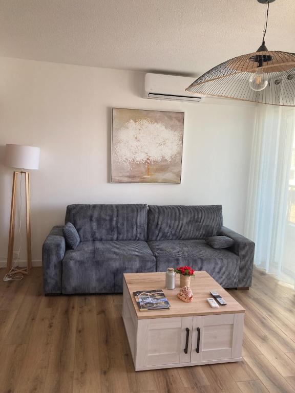un salon avec un canapé et une table basse dans l'établissement Superbe T3 moderne vue mer avec parking, climatisation, piscine, à La Grande Motte