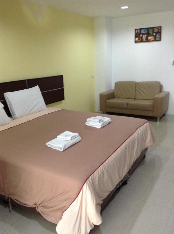 a bedroom with a large bed with two towels on it at Diamond Bangkok Apartment in Bangkok