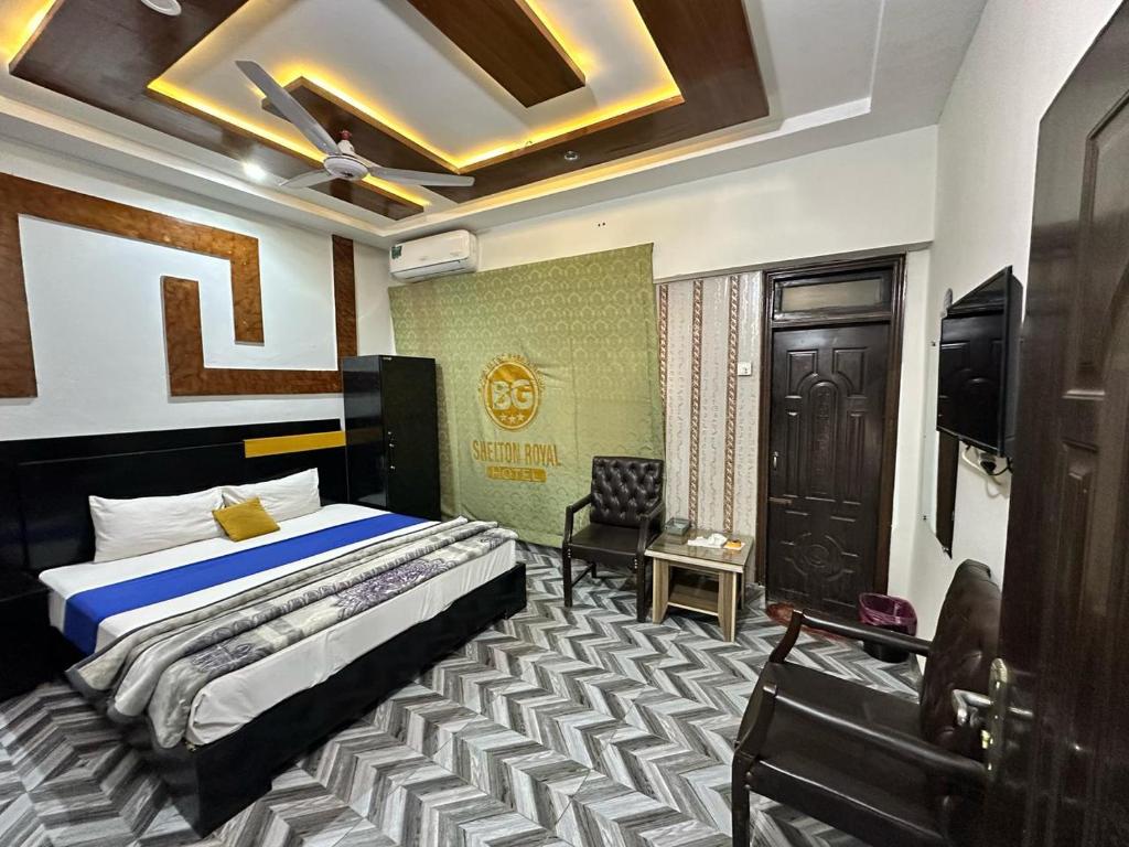 a hotel room with a bed and a tv and a bed sidx sidx at Shelton Royal Hotel in Multan