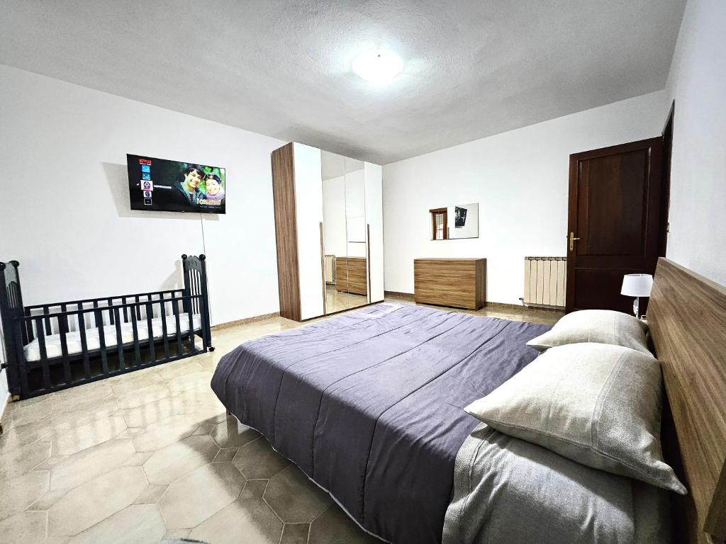 a bedroom with a bed and a flat screen tv at House Riky in Assemini