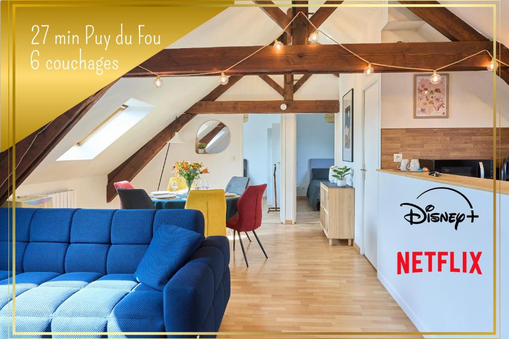 un salon avec un canapé bleu et une cuisine dans l'établissement L'Infini Choletais - Netflix et Climatisation, à Cholet