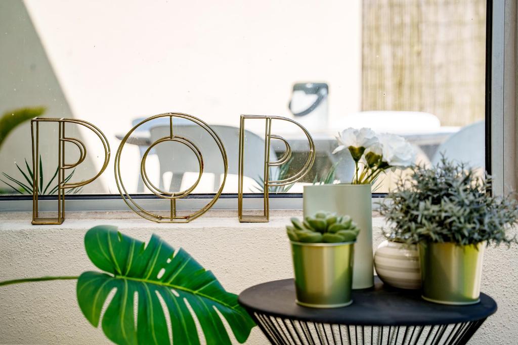 a table with potted plants and a sign that readsarma at La Villa Pop in Joue-les-Tours