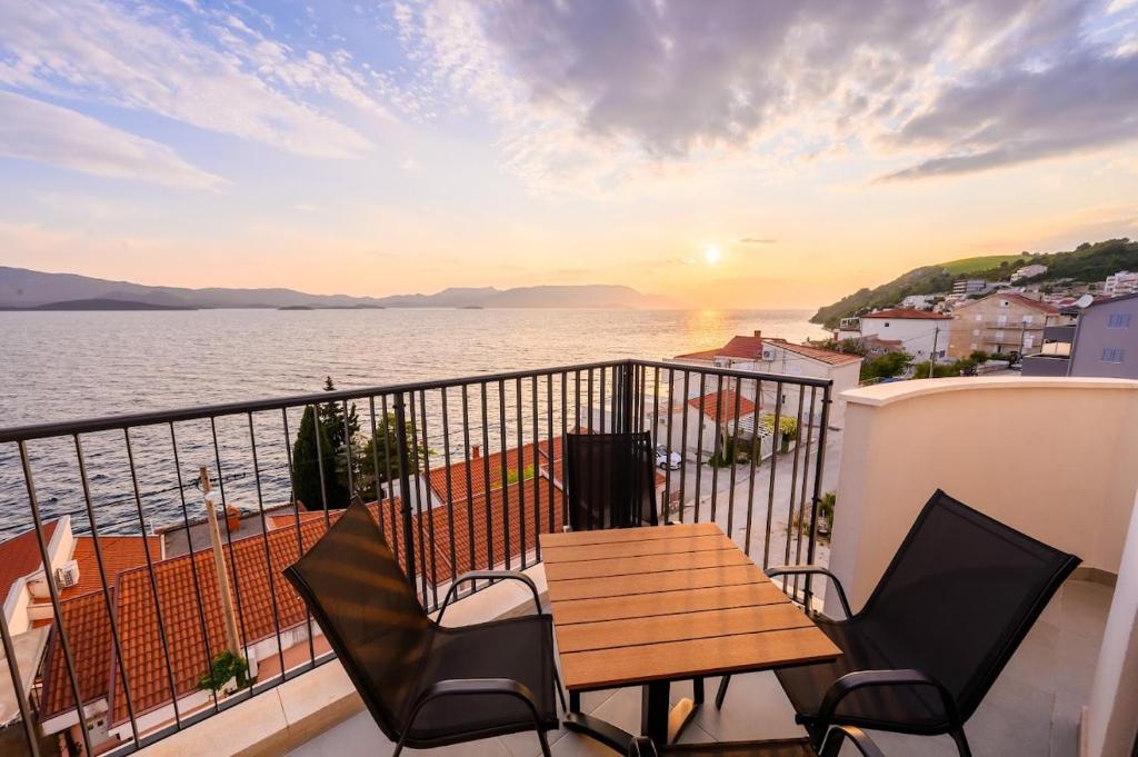 a balcony with a table and chairs and a view of the water at Apartments Sunset Komarna in Komarna