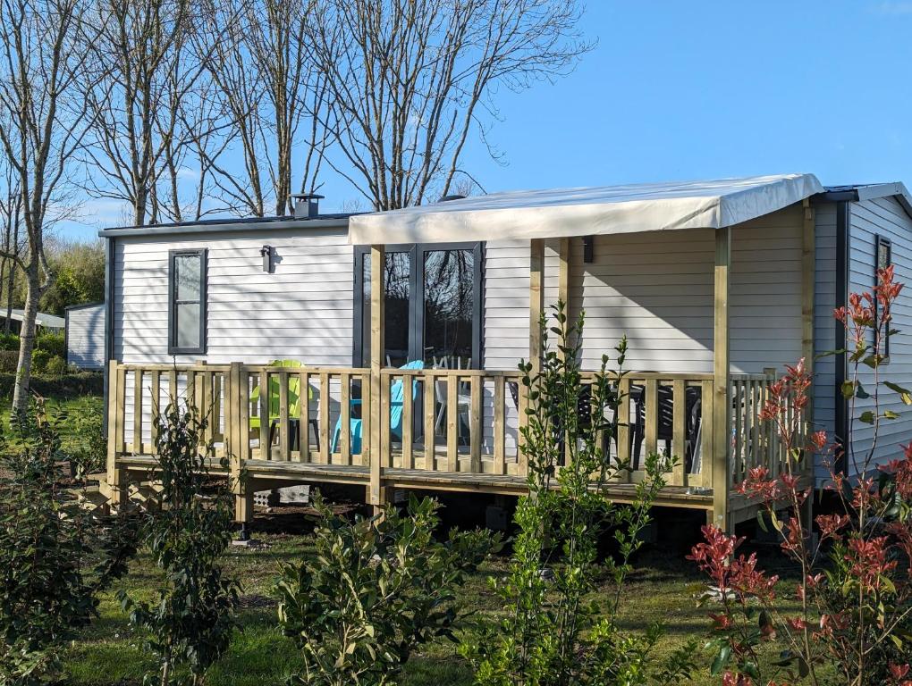 a tiny house with a porch and a deck at Camping de Lanven in Plomeur