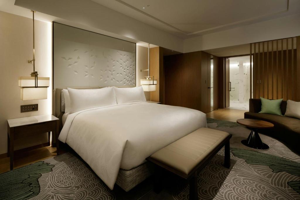 a bedroom with a large white bed and a couch at JW Marriott Hotel Nara in Nara