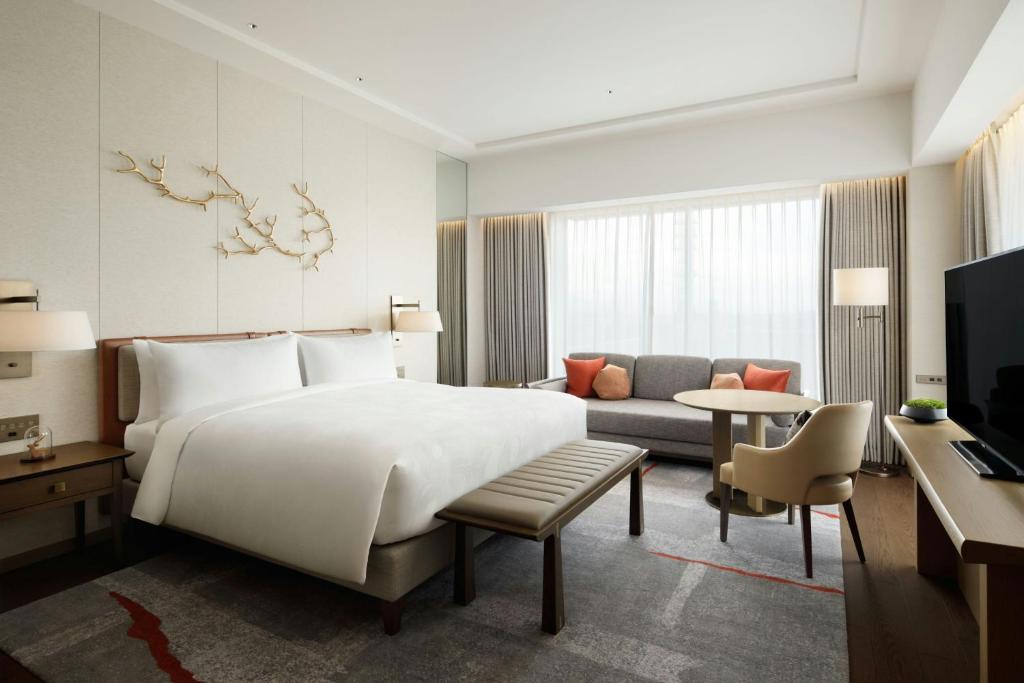 a bedroom with a large white bed and a couch at JW Marriott Hotel Nara in Nara