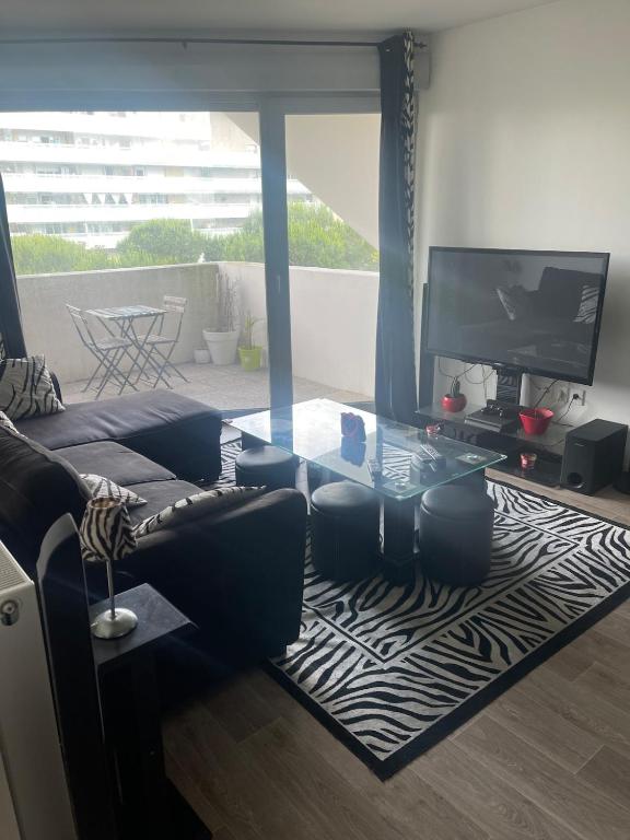 un salon avec un canapé et une table en verre dans l'établissement 2-room apartment, à Bayonne