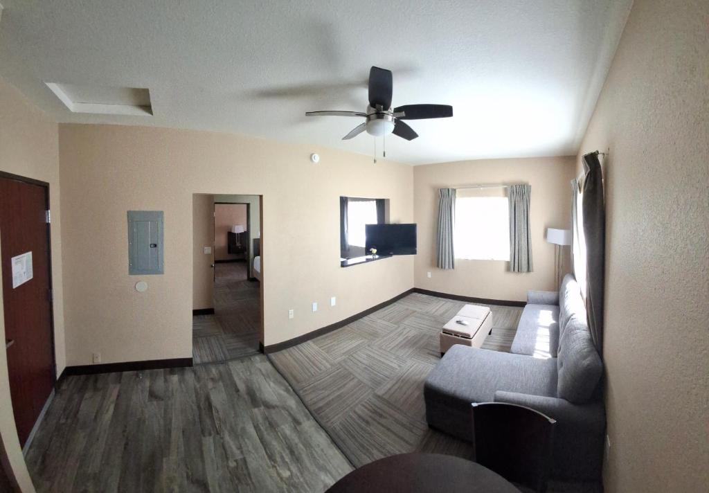 Una sala de estar con un sofá y un ventilador de techo. en Island Suites, en Lake Havasu City