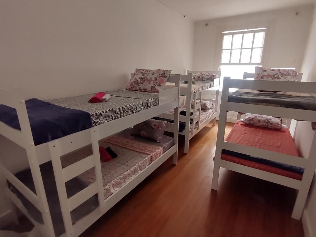 ein Zimmer mit drei Etagenbetten und einem Fenster in der Unterkunft Hostel SP&Bed in São Paulo