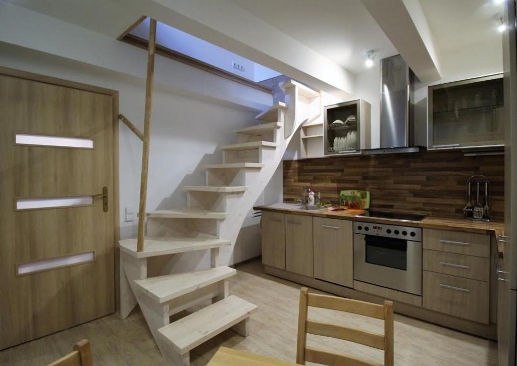 a kitchen with a spiral staircase in a kitchen at Old town apartaments in Kaunas