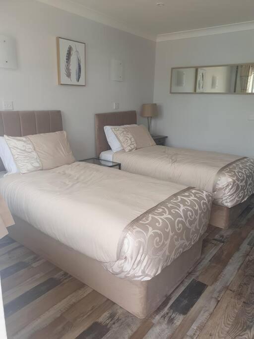 two beds sitting in a room with at Willow Lodge In Hexton in Hexton