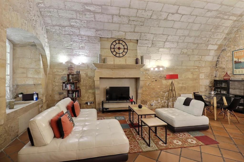 a living room with a couch and a fireplace at appartement centre historique in Bordeaux