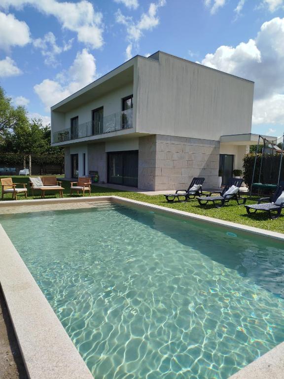 a swimming pool in front of a house at Balutinha's house in Barcelos
