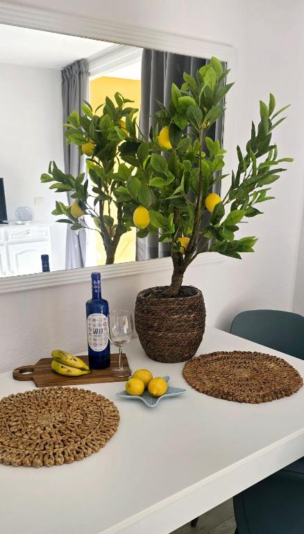 a white table with a plant and fruits on it at Las Americas Blue Ocean Apartment in Costa de Adeje