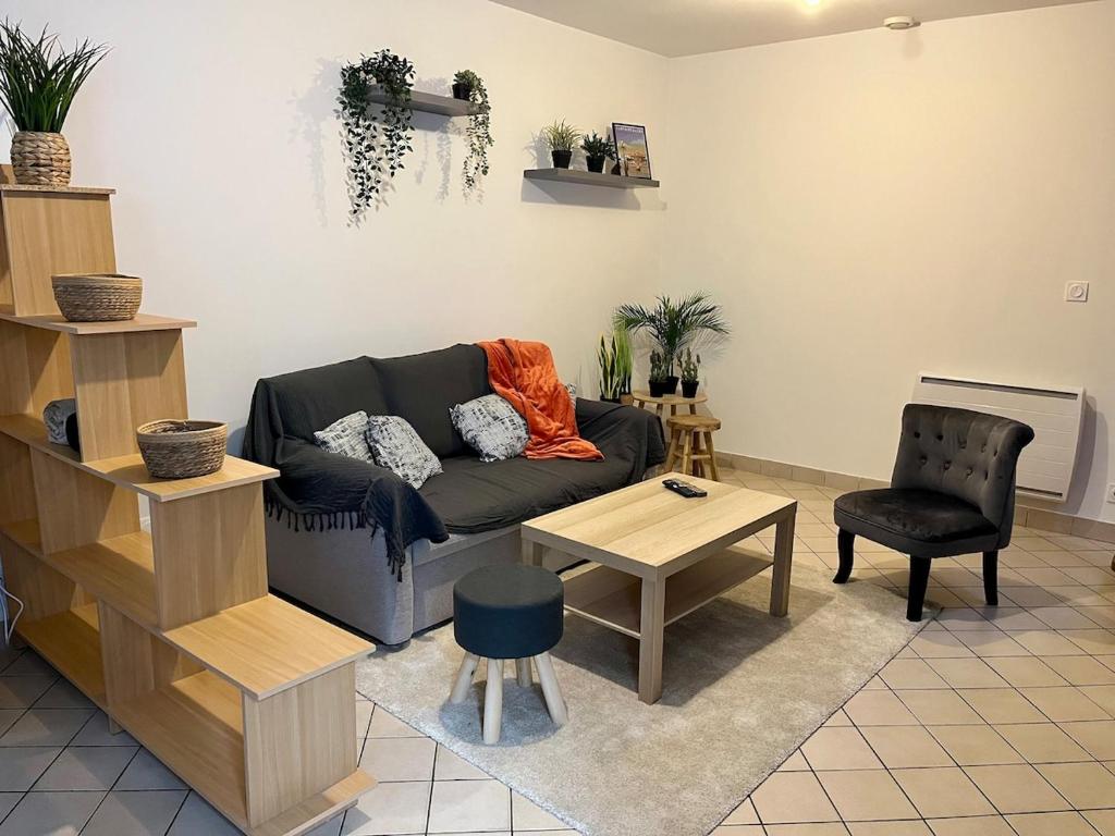 un salon avec un canapé et une table dans l'établissement Charming furnished house at Moret sur Loing, à Moret-sur-Loing