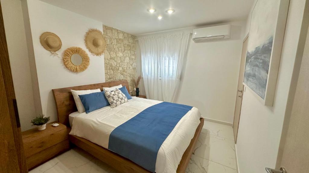 a bedroom with a bed with blue and white sheets at Marko's Place in Hanioti
