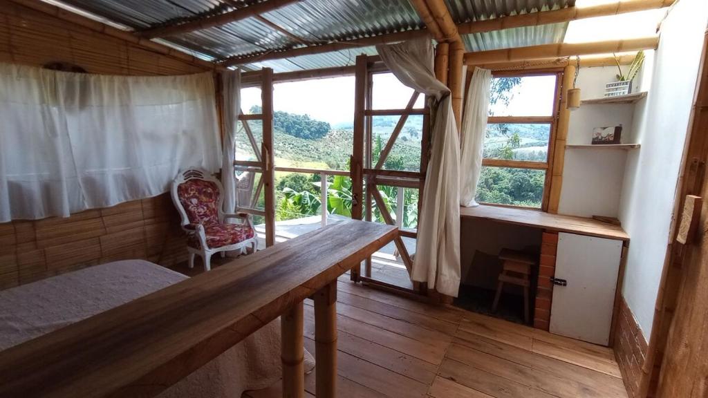 a room with a table and a chair and a window at Hospedaje Rural La Trinchera Mirador a la montañas Cerro Azul Trujillo in Trujillo