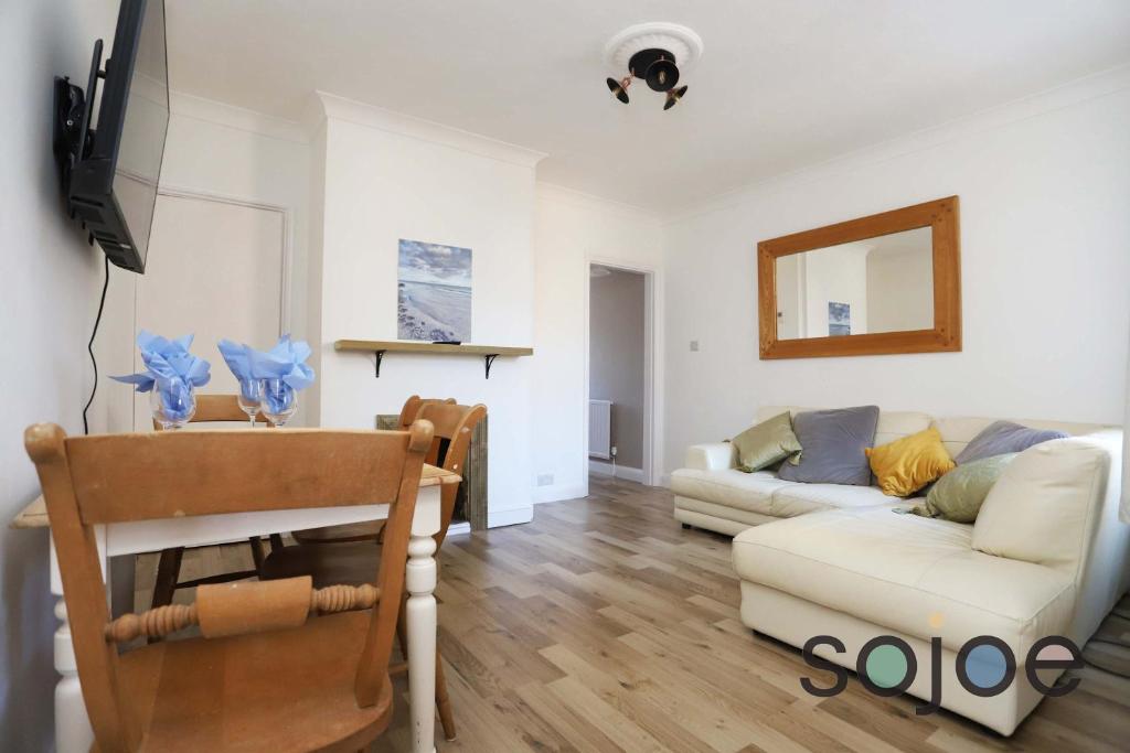 un salon avec un canapé et une table dans l'établissement Seaside cottage close to beach, à Pakefield