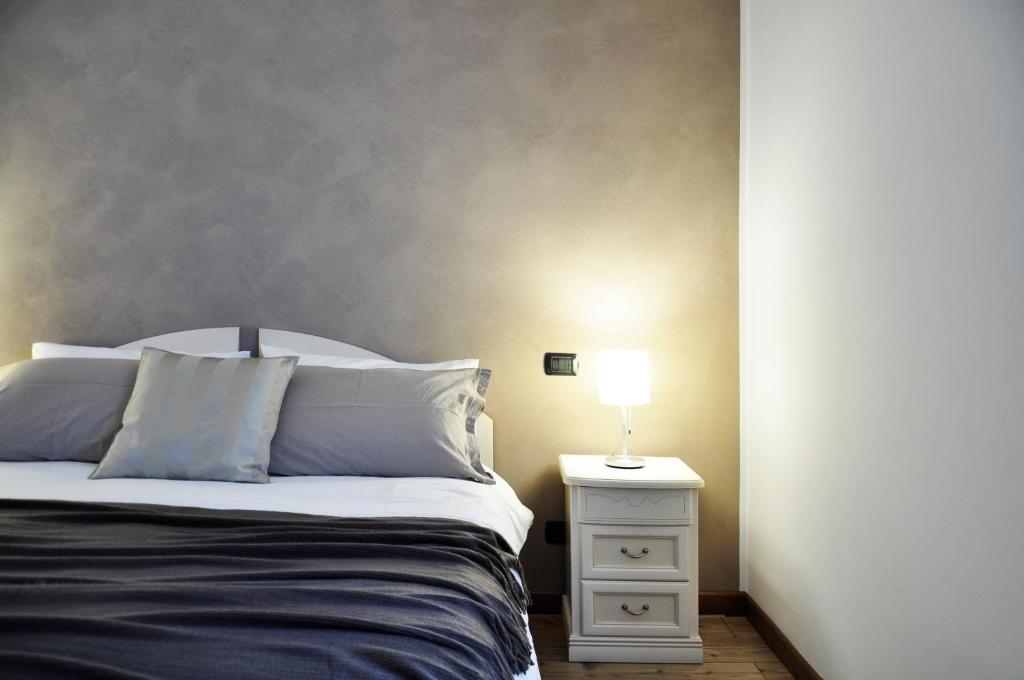 1 dormitorio con cama y mesita de noche con lámpara en Alc&cE' alloggio agrituristico, en Povoletto