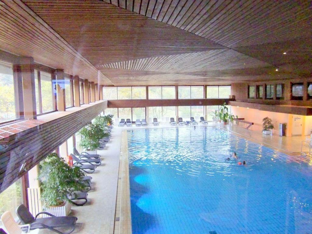 a large swimming pool in a building with chairs at Seeseite-Romantik-Apartment in Timmendorfer Strand