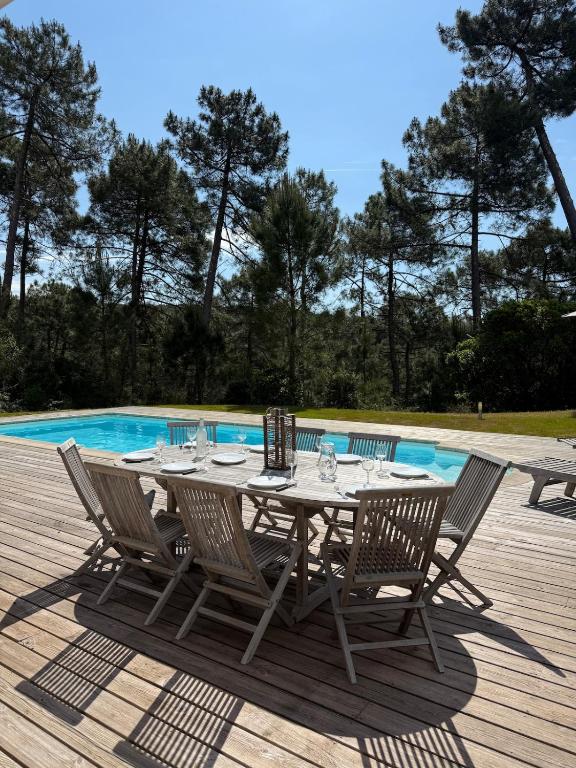 - une table et des chaises à côté de la piscine dans l'établissement Villa avec piscine 8p autour du golf, à Lacanau
