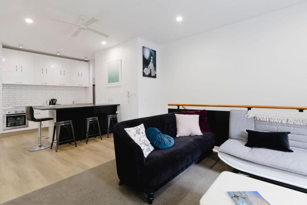 a living room with a couch and a kitchen at Spacious 3BR Retreat on City Fringe w Free Parking in Wellington