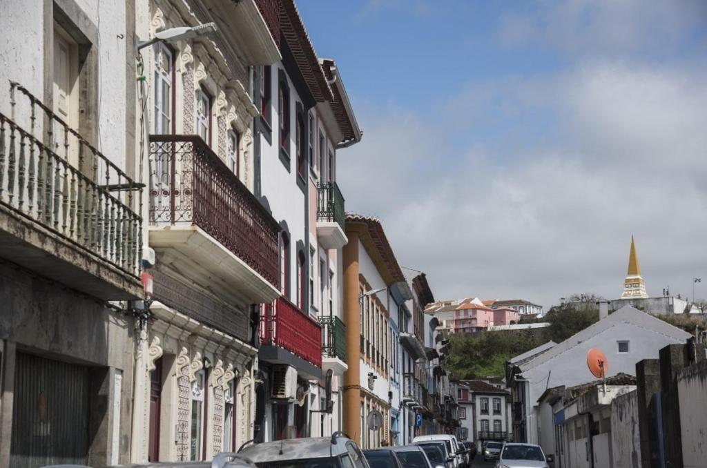 a city street with cars parked on the sides of buildings at Sé House View in Angra do Heroísmo