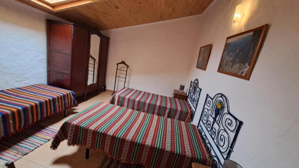 a room with two beds and a table and chairs at Monte das Sorraias Casa Emília in Castro Verde