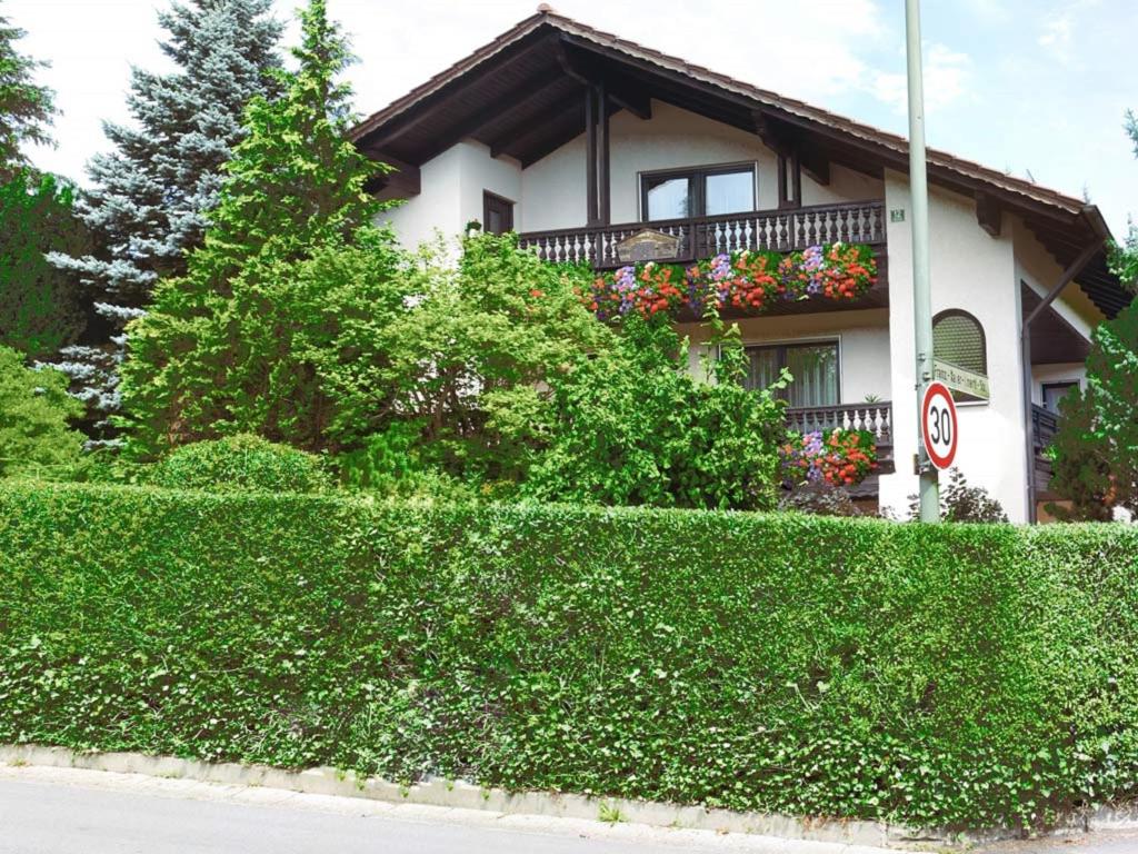 a house with a hedge in front of a building at Gästehaus Steiger in Bad Birnbach
