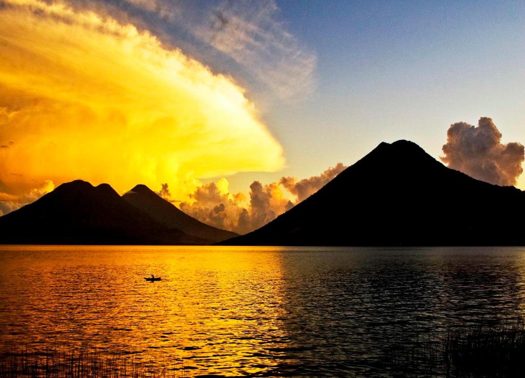 a sunset over a lake with mountains in the background at Cuarto 2 in San Marcos La Laguna