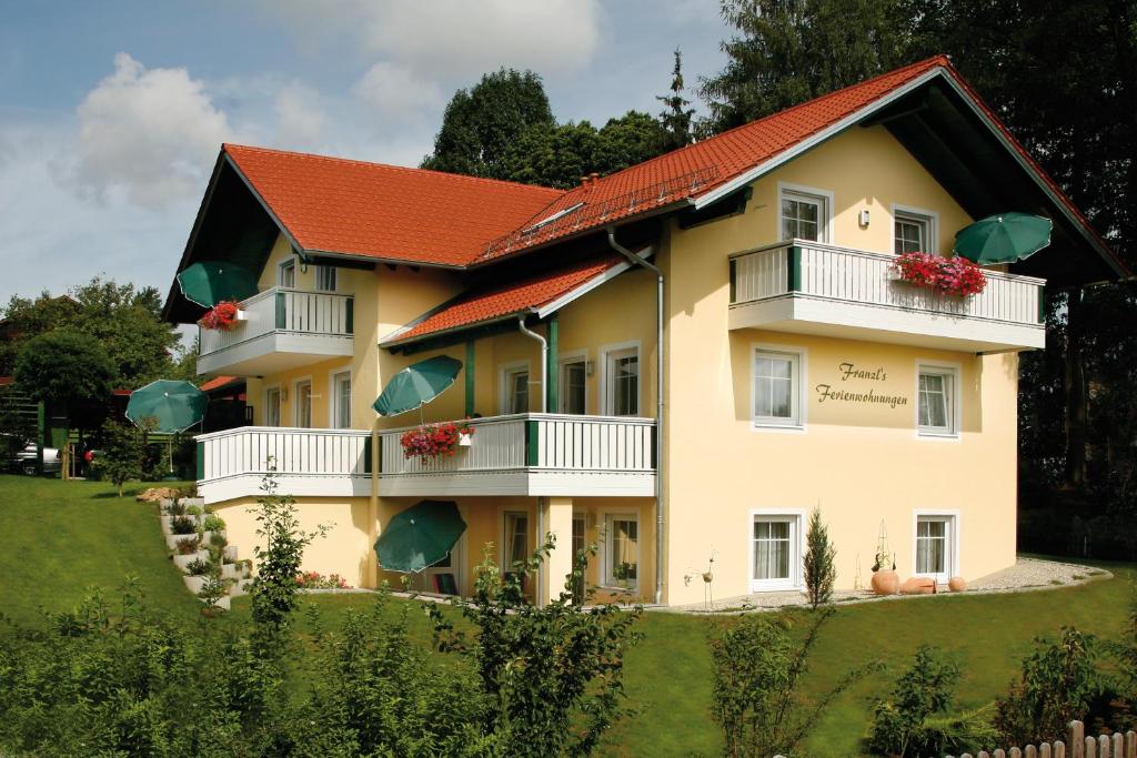 ein großes gelbes Haus mit rotem Dach in der Unterkunft Franzl's Ferienwohnungen in Bad Birnbach