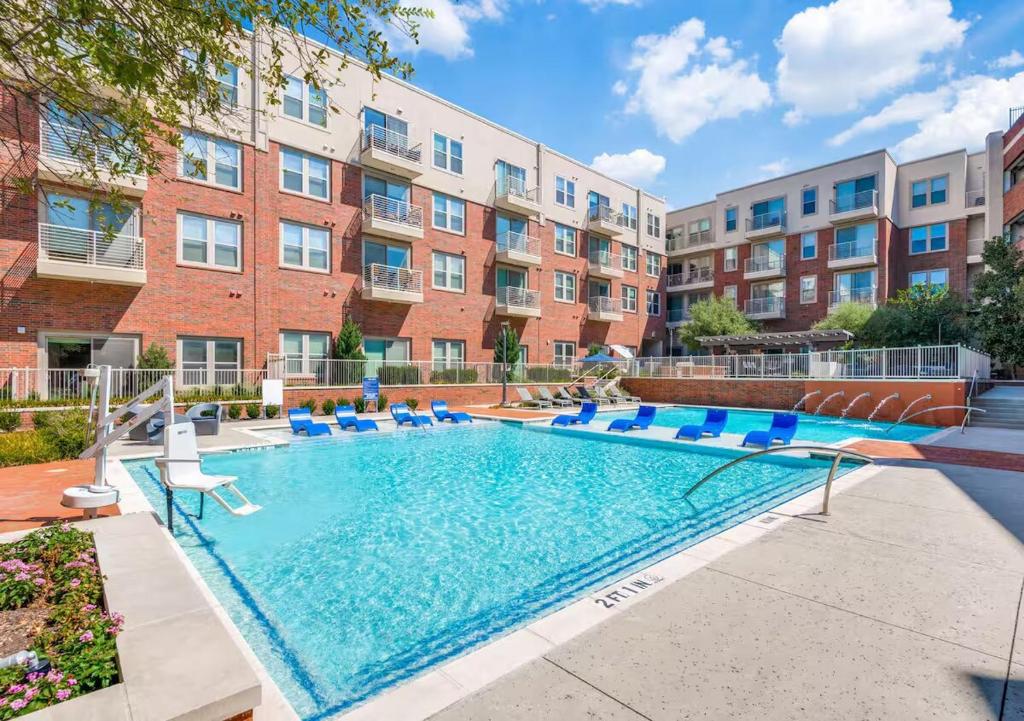 弗赖拉辛2 BR Heart of Frisco Gem的带椅子的游泳池和一栋建筑