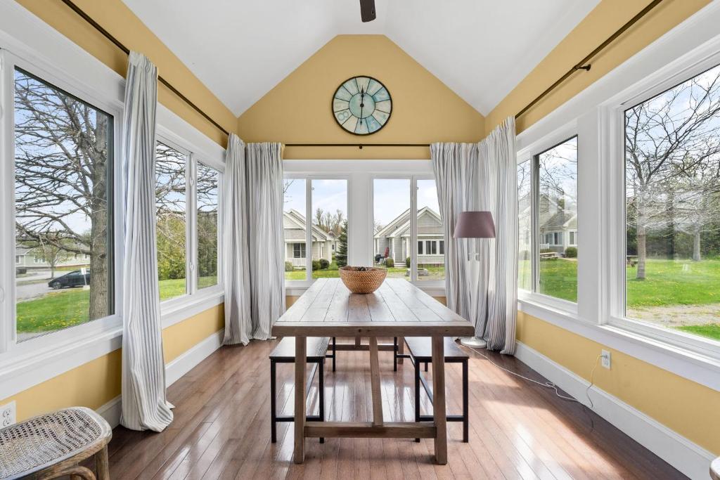 a dining room with a table and windows at The Cottontail - 6 Meadowview Lane in Cherry Valley