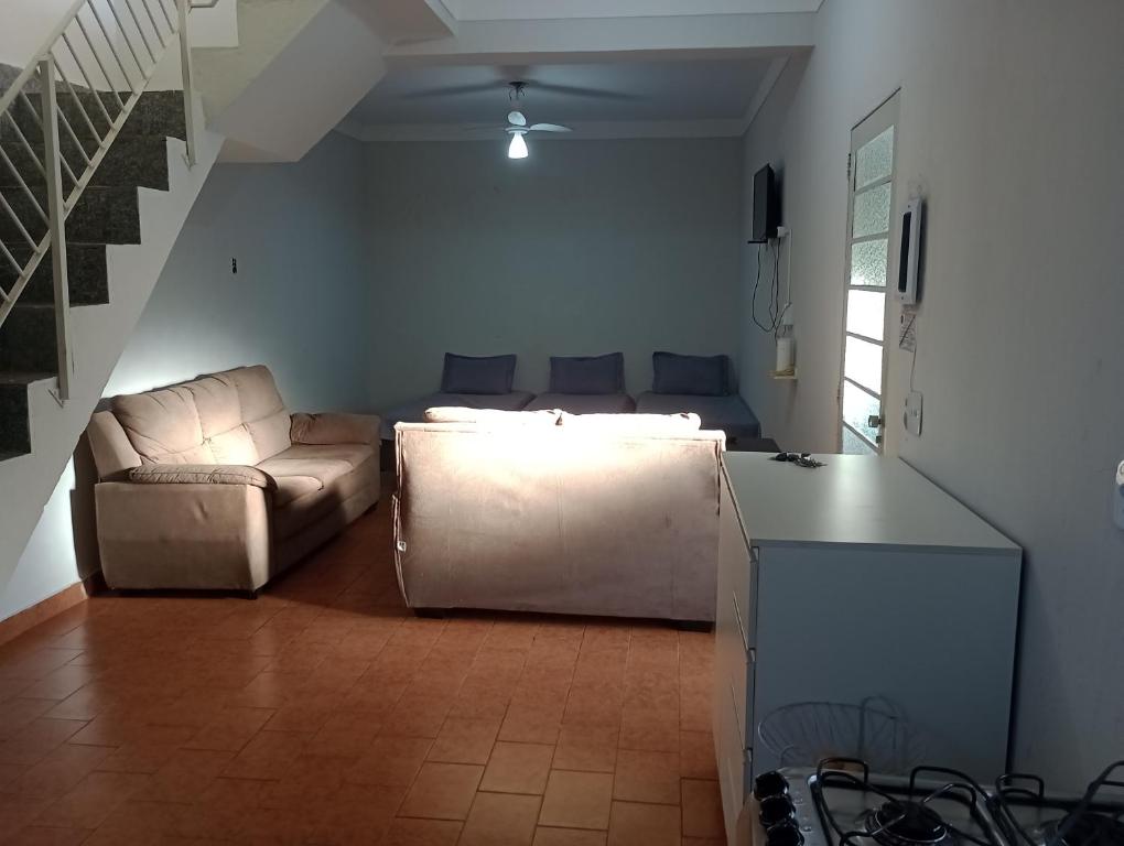 a living room with a couch and a living room at Espaço Gardenias II in Guaratinguetá