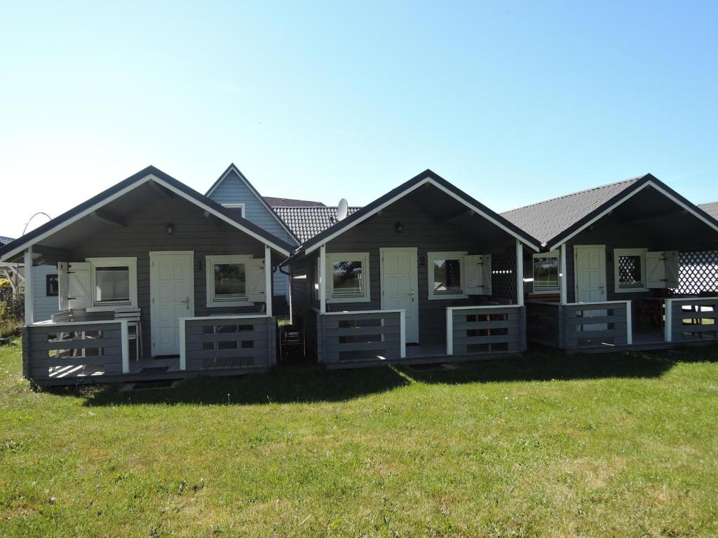 a row of houses sitting on a grass field at Holiday Home Dziwnówek near Baltic Sea in Dziwnówek