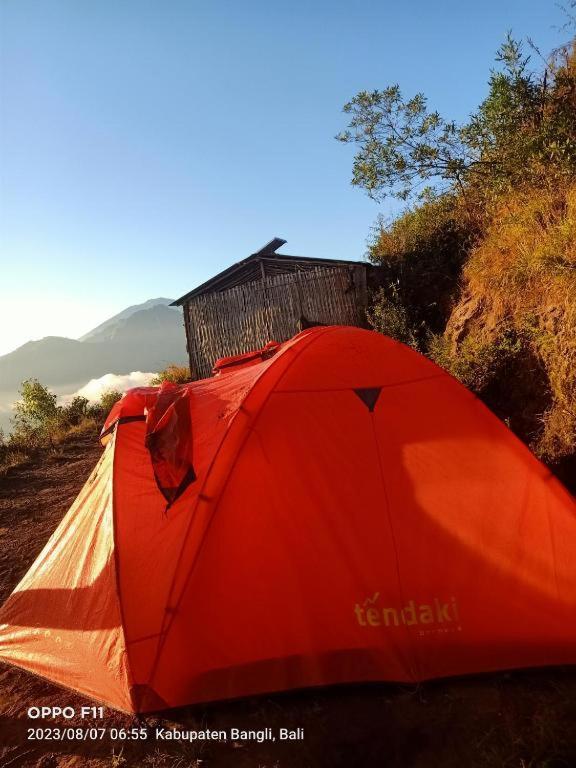 a red tent sitting on the side of a hill at Batur Sunrise Camp in Kintamani