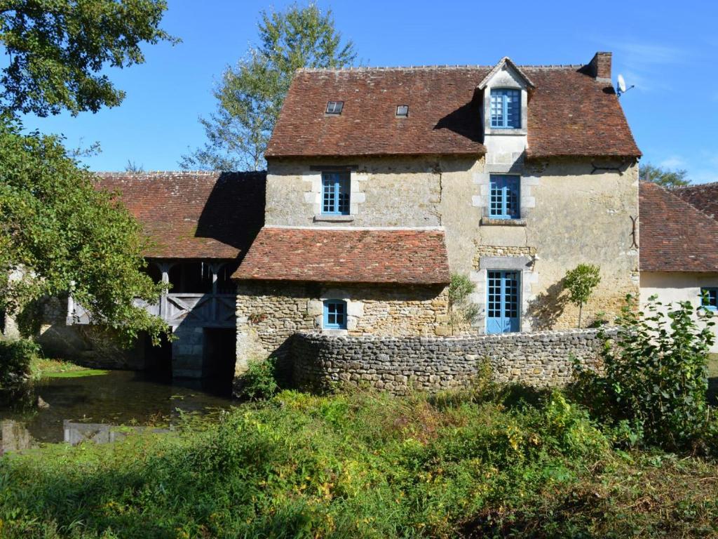 an old stone house with a brick wall at Moulin atypique du XVème siècle avec jardin clos - FR-1-381-483 in Arpheuilles