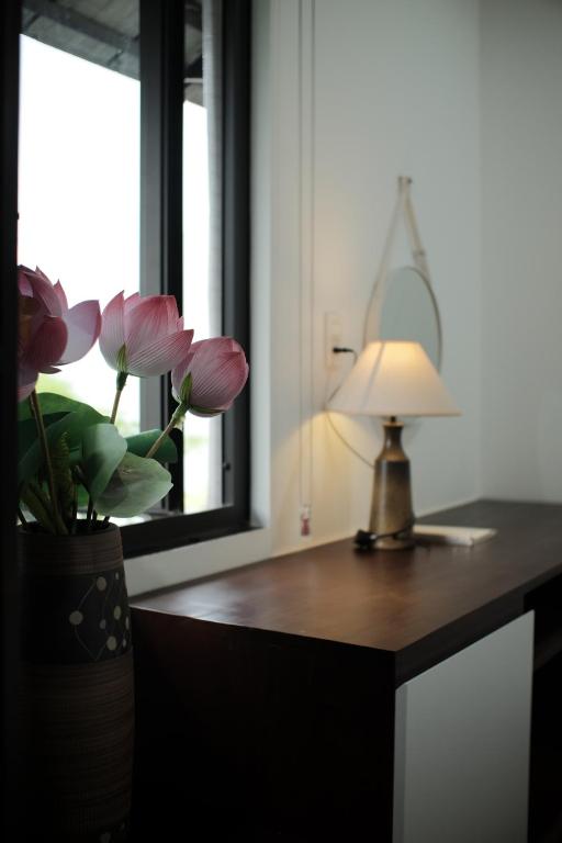 a desk with a lamp and a vase with flowers on it at 750sqm Private Pool-Villa Hue in Cồn Giả Viên