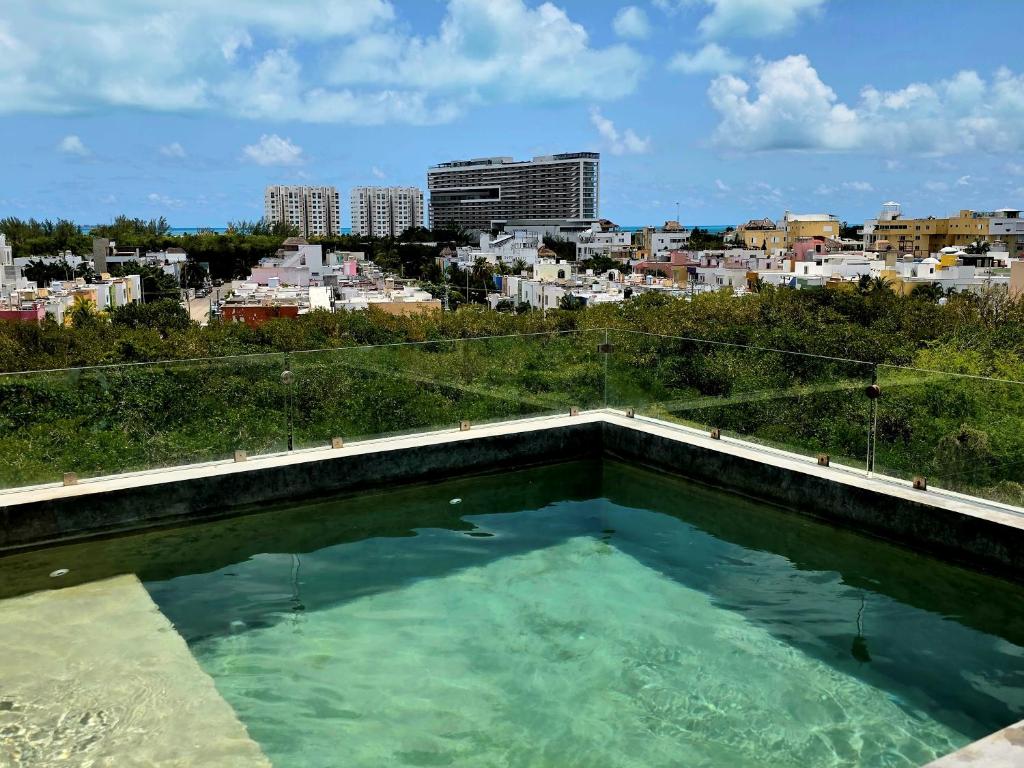 a swimming pool with a city in the background at Mangle 13 Modern Apartments-Rooftop pool, close to Ferry in Cancún
