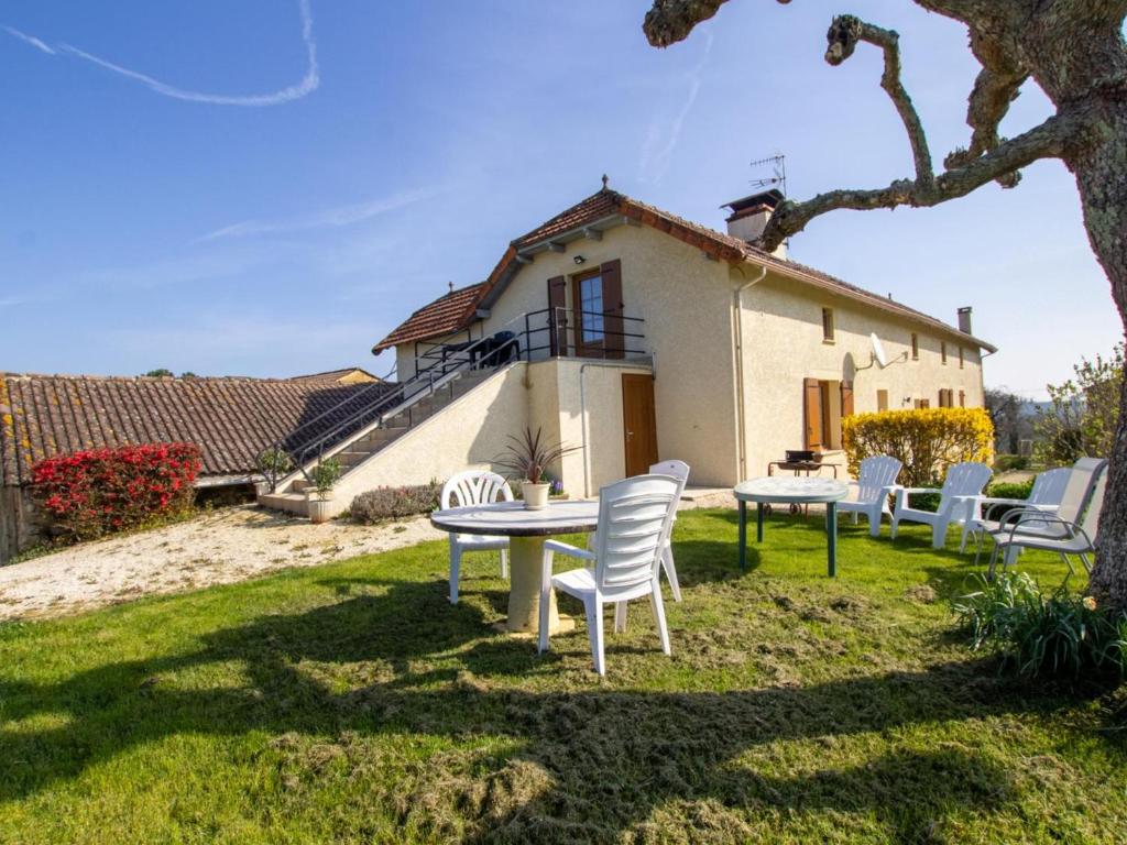 a table and chairs in front of a house at Maison de campagne spacieuse près de Sarlat avec jardin - FR-1-616-22 in Doissat