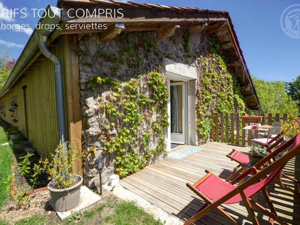ein Haus mit einer Holzterrasse mit Stühlen darauf in der Unterkunft Studio Montagne Paisible, Terrasse, Animaux Bienvenus - FR-1-496-224 in Saint-Priest-la-Prugne